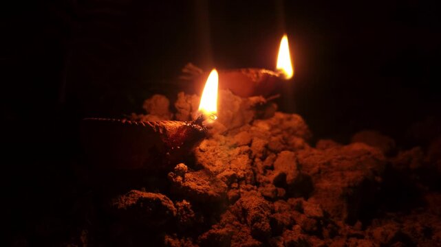 Traditional Clay Oil Lamps Diyas Burning with Glowing Flames in Darkness, Hindu Festival Diwali Celebration, Spiritual Prayer Light, Warm Candlelight, 4K Cinematic Stock Footage