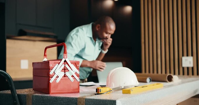 Phone call, renovation and toolbox with black man in kitchen for home improvement or upgrade. Communication, construction and laptop with mature contractor in modern apartment for building project
