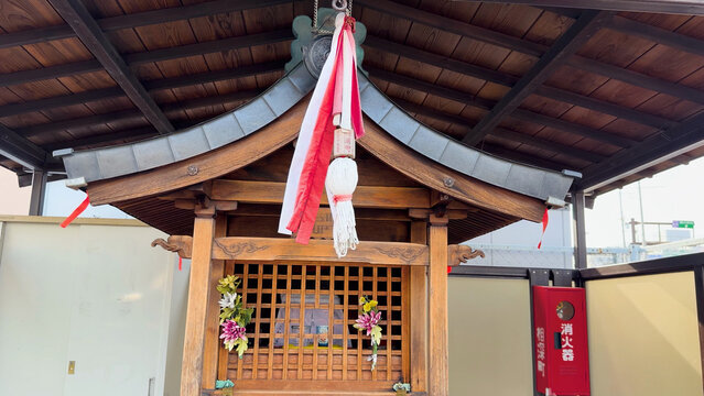 Traditional Wooden Shinto Shrine with Red and White Suzu Bell Rope