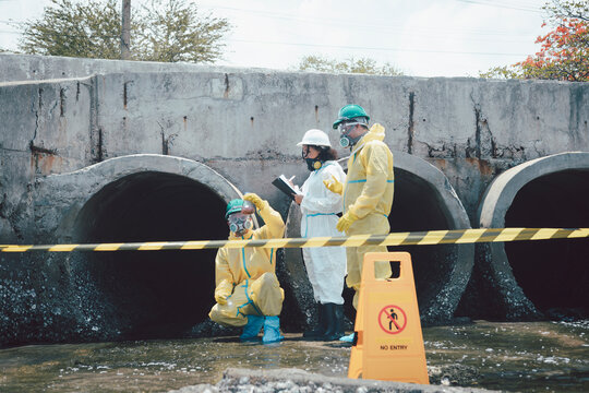 Environmental scientists collected water samples near industrial wastewater systems and examined hazardous materials in protective gear for wastewater pollution testing.