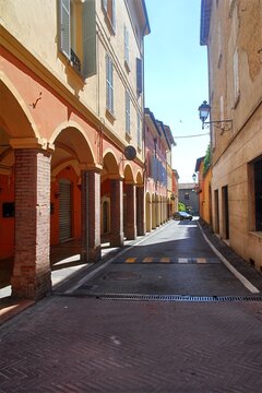 Historic street with traditional porticoes and archways in Modena, Italy