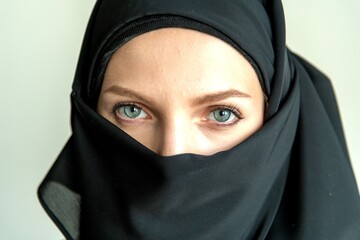 Naklejka premium Eyes framed by black fabric.