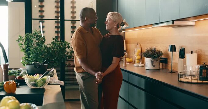 Dancing, happy and couple in kitchen for cooking with music for bonding, love and connection. Interracial, care and mature man with woman for moving to romantic playlist with preparing meal in home.