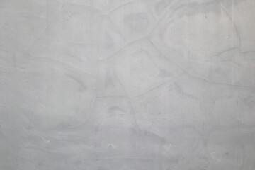 Weathered gray concrete wall texture background with water stains and hairline cracks