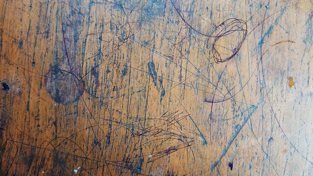 Scratched and scribbled old wooden school desk texture background