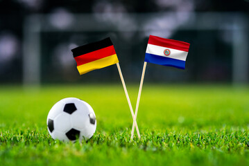 Obraz premium Germany vs Paraguay, national flags before international football tournament Round of 32 match, football on green grass with goal in the background, Foxborough, Massachusetts, USA, June 29, 2026