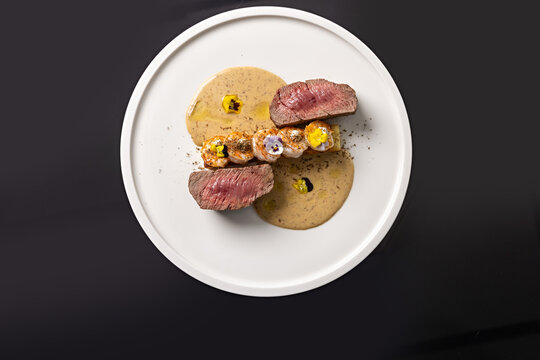 Top view of a dish with beef tenderloin steak and grilled prawns