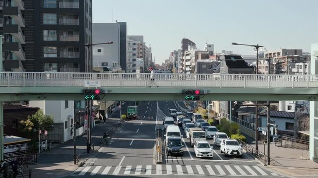 Tokyo Scene  :  Large Pedestrian Overpass Spanning an Intersection Where Arteries Meet at a Metropolitan Junction. The Traffic Light Changes and the Cars Begin to Move  |  Shibuya, Tokyo, Japan