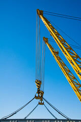 Fototapeta premium Loading in port. Floating port crane on blue sky background