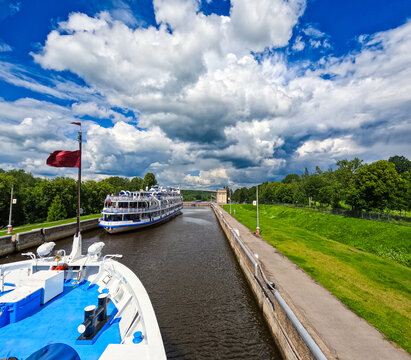 A cruise ship in a picturesque canal lock.
