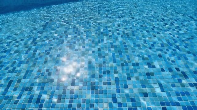 Bright Sun Glare Reflection on Moving Blue Mosaic Tile Water Texture inside Outdoor Swimming Pool