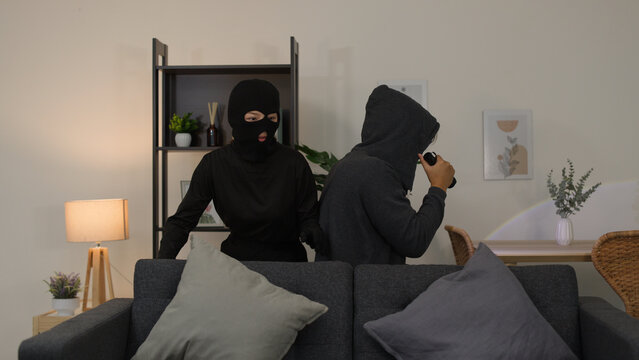 Two Masked Intruders Searching a Modern Living Room at Night