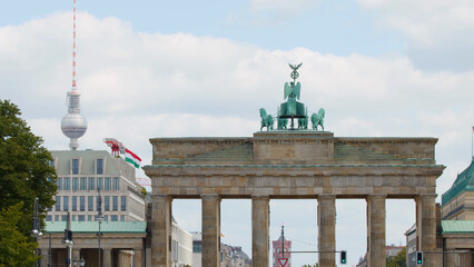 Naklejka premium Brandenburg Gate with Quadriga Sculpture and Berlin TV Tower Background