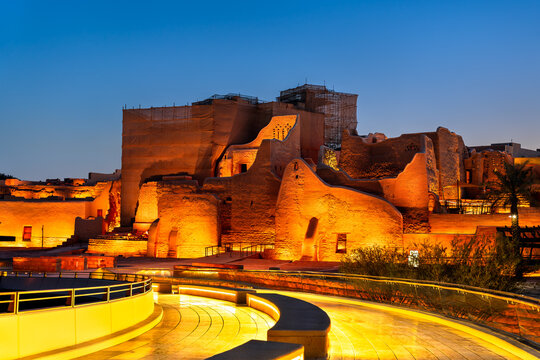 Beautifully illuminated ruins of the historic At-Turaif district above the pedestrian bridge in Diriyah Saudi Arabia during twilight