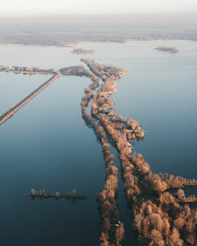Aerial view of the narrow wooded peninsula surrounded by the calm waters of the Loosdrechtse Plassen in Scheendijk, Breukelen, Utrecht, Netherlands.