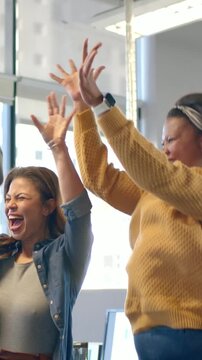 Vertical video: Placing hands team pulling up at office near window mustard sweater celebrating win