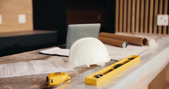 Laptop, helmet and building with construction documents for architecture, maintenance or planning. Empty, hard hat and computer with paperwork or floor layout for PPE safety, tools and installation