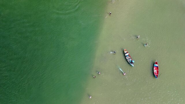 Fishing with dolphins, authentic fishing tradition in Brazil. Aerial view of the group of fishermen collaborating and fishing together with dolphins