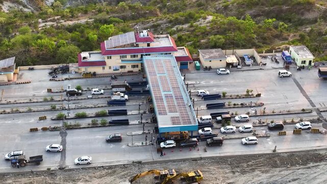 Drone shot of cars passing through automated fastag toll plaza gates.