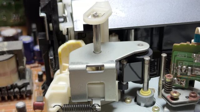 The internal gears and magnetic head of the VCR spin rapidly to read the VHS tape. This action creates a steady mechanical whirring sound and a faint, rhythmic hiss as the reels rotate.
