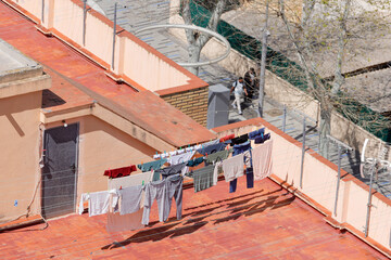 Photo of clothes drying pegged on a washing line on top of a Spanish apartment block showing the laundry drying on top of the high rise building with the wind blowing in the fresh air © Duncan