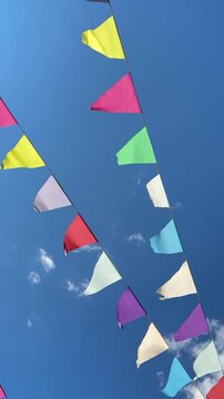 Colorful bunting garland flags fluttering against clear blue sky