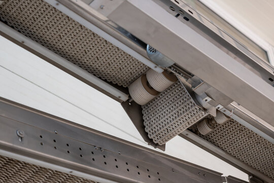 Close-up of white rollers on a modular belt conveyor.