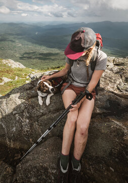 Woman hiker petting her dog on a mountain along the Appalachian Trail.