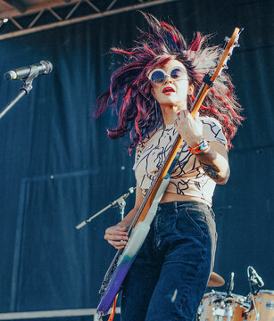 Female bassist flips her colorful hair on stage