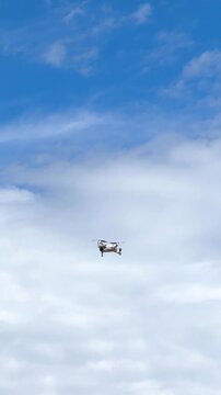 A small drone in a field with a blue sky in the background