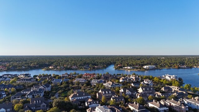 Aerial view of large mansion houses with swimming pool, in affluent neighborhood by Woodlands lake, Houston, Texas, expensive suburban homes surrounding by lush green trees, USA	
