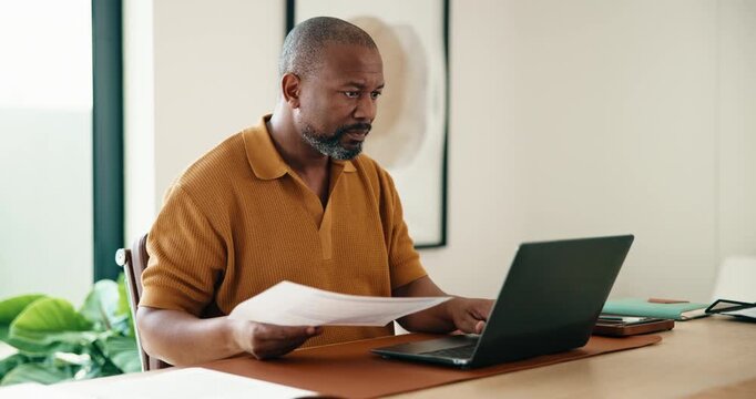 Documents, laptop and remote work with black man in home office for report, research or review. Computer, paperwork and planning with mature person in apartment for feedback as freelance employee