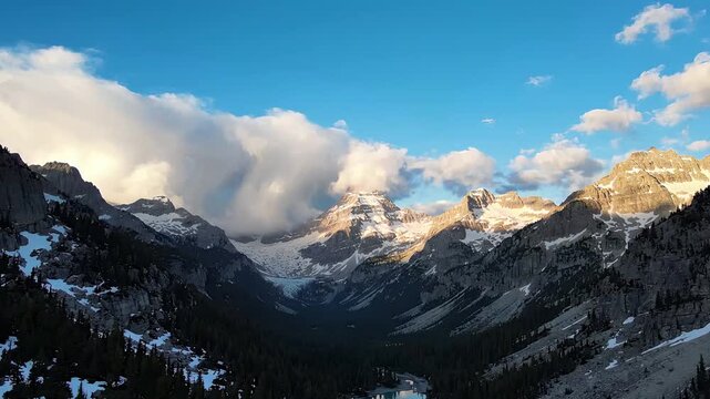 Panoramic view of snow capped mountains under blue sky with white clouds