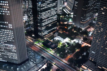 夜空の下で輝く高層ビル群と街路灯の灯りが織りなす都会的な夜景。 © BRUCE