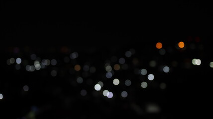 White and orange bokeh lights glow softly against a dark background, creating a peaceful abstract night scene with cinematic mood and minimalist beauty. © onyengradar