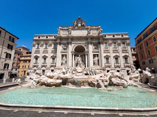 Fototapeta premium Fontaine de Trevi à Rome, chef-dœuvre baroque du XVIIIe siècle avec Neptune en marbre blanc et bassins scintillants, monument le plus célèbre d'Italie sous ciel bleu