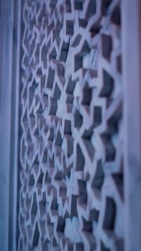 Intricate geometric arabesque pattern carved into marble, traditional islamic architecture detail, intricate lattice texture, architectural background
