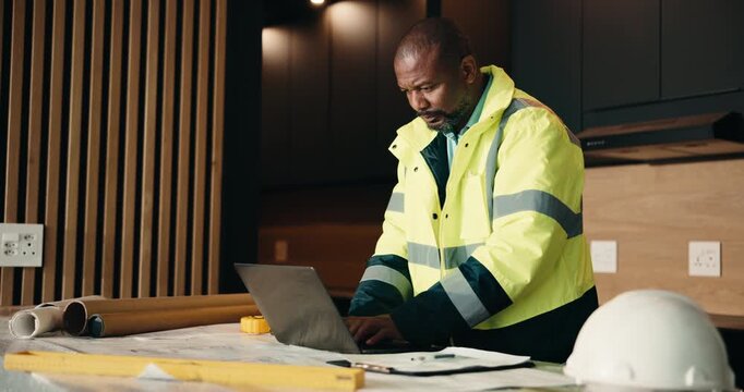 Laptop, renovation and thinking with black man in kitchen for home improvement or upgrade project. Computer, typing and writing with mature construction worker in modern apartment for property update