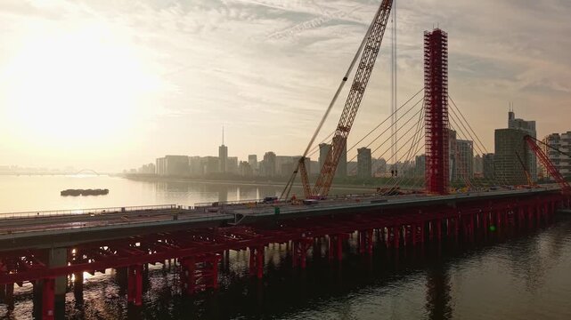 Aerial view of bridge sections being dismantled with a large crane over a river