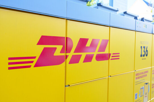 Iserlohn, Germany - June 18, 2026: DHL logo prominently displayed on a yellow Packstation, an automated parcel locker for package delivery