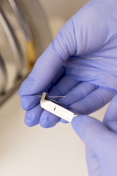 Braces adjustment with orthodontic pliers and archwire in dentist hands