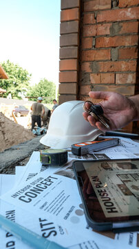 Construction site overview with blueprints, tools, and keys, symbolizing project completion