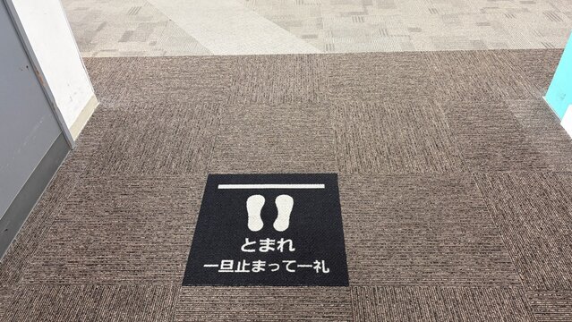 「一旦止まって一礼」の床面サイン。ショッピングモール職員通路の接客マナー標識