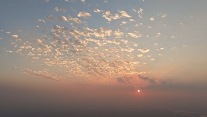 Obraz premium High Elevation Static Shot Glowing Scattered Pastel Clouds Sunrise Hazy Horizon Sky