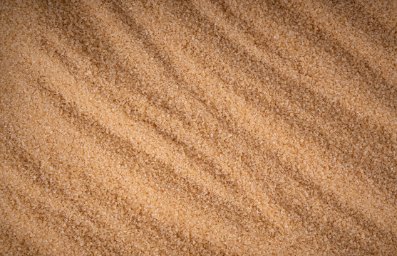 Brown cane sugar pile textured background top view