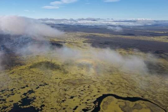 Aerial view of the moss-covered lava fields of Laki with a faint glory phenomenon visible in the clouds over the volcanic landscape in Kirkjubaejarklaustur, Skaftarhreppur, Iceland.