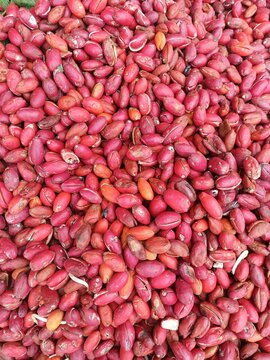 A heap of fresh red paddy oats skin or gnetum gnemon peel displayed at a traditional market