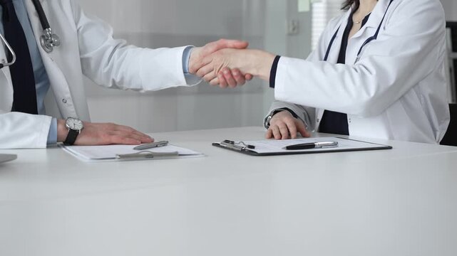 Doctors shaking hands, symbolizing partnership, trust, and successful agreement in a healthcare setting. Medical team meeting