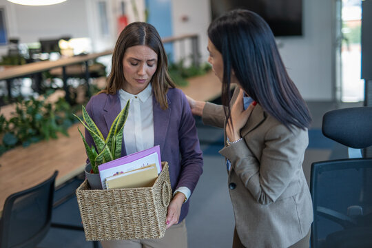 Woman carrying a basket of belongings after being laid off from her job