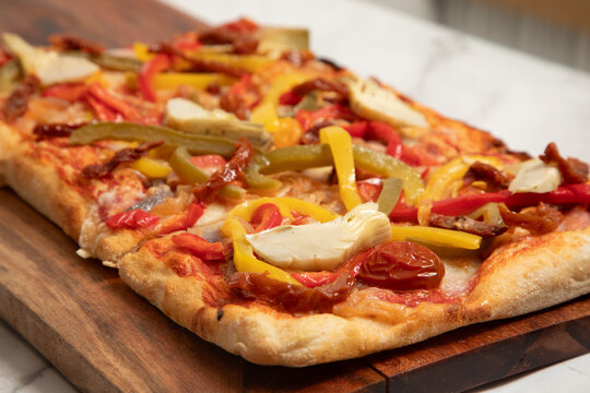 Pizza rectangulaire avec l&eacute;gumes sur une planche en bois